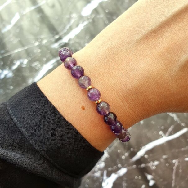 Amethyst bracelet catching natural light – crystal jewellery for spiritual protection and higher awareness.