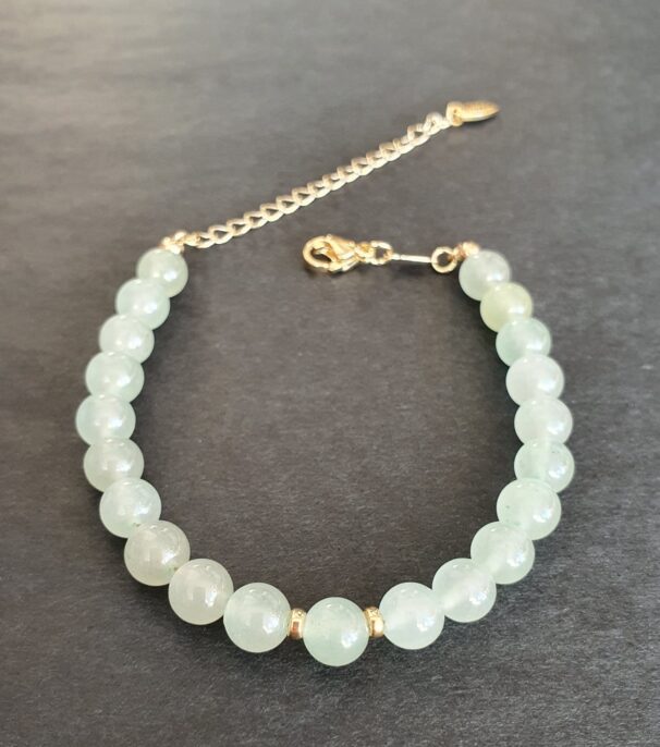 Green aventurine bracelet placed on fabric – crystal jewellery for good luck, calm, and renewal.