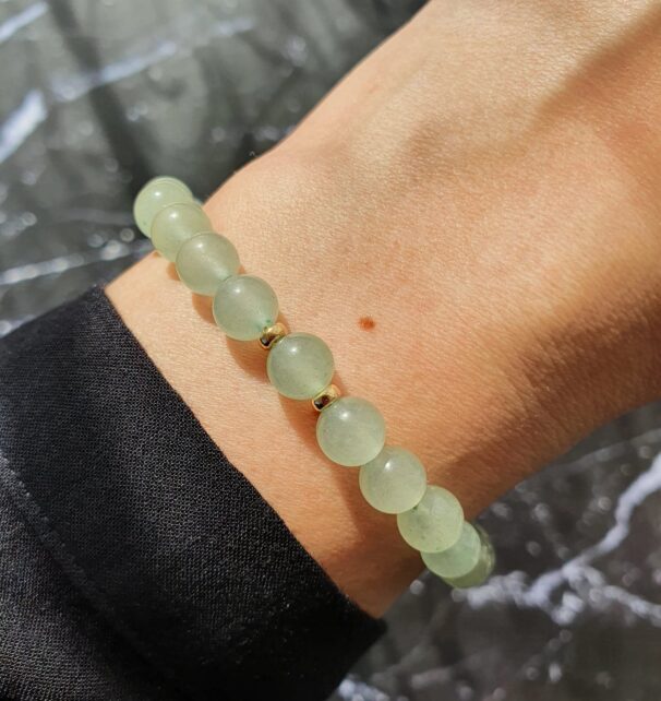 Close-up of green aventurine bracelet on wrist – crystal bracelet for attracting abundance and soothing emotions.