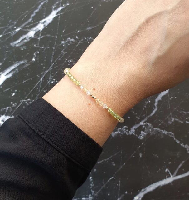Woman wearing a dainty citrine and peridot crystal bracelet – gemstone jewellery for confidence, growth, and emotional balance.